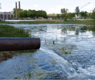 Water pouring into a settling pond from a pipe